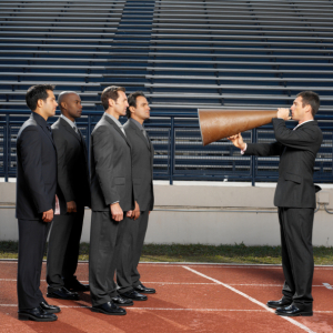 businessman talking through megaphone to businesspeople, side view